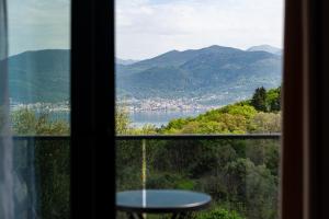 a window with a view of a lake and mountains at Casa Bellavista in Tivat
