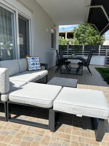 a patio with two couches and a table and chairs at Coral Nikiti Apartments I in Nikiti