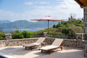 a patio with two chairs and an umbrella at Casa Bellavista in Tivat