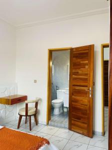 a bathroom with a toilet and a wooden door at Rieti Yamehome in Yaoundé +31 photos