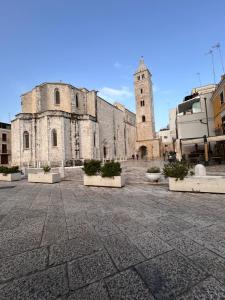 an old building with a clock tower in a courtyard at Marra Home B&B in Barletta