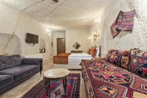 a living room with a couch and a bed at Tatlı Kaya Cave Otel in Ürgüp