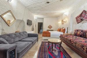 a living room with a couch and a bed at Tatlı Kaya Cave Otel in Ürgüp