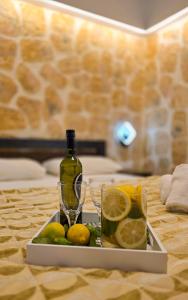 a tray with a bottle of wine and lemons on a table at Casa Bella a Skala 1 in Skala