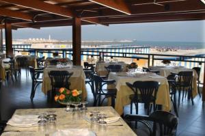 a restaurant with tables and chairs with a view of the beach at Marra Home B&B in Barletta