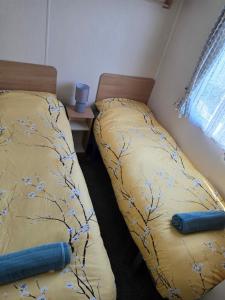 two beds sitting next to each other in a bedroom at Ollys House in Prestatyn