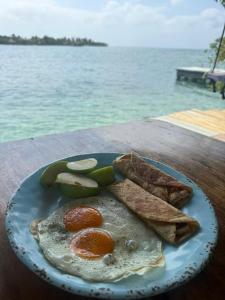 a plate of food with eggs and bread on a table at Casa Acuarimantima in Tintipan Island