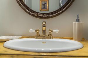 a bathroom sink with a faucet and a mirror at Walkable Designer Cottage In GV in Columbus +30 photos