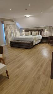 a large bedroom with a large bed and wooden floors at Pousada Itália Moderna in Campos do Jordão