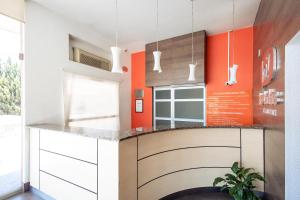a kitchen with orange walls and a counter at Hotel Hi! Zapopan in Guadalajara