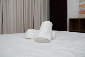 a pile of towels sitting on top of a bed at 206 Executive Granvia Suites in Cagayan de Oro
