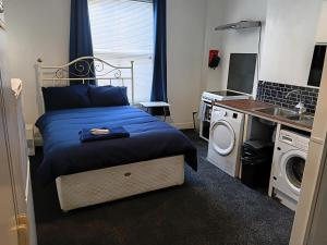 a bedroom with a bed and a washing machine at Liv's place in Oldbury
