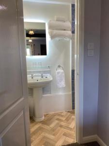 a bathroom with a sink and a mirror at Primrose Cottage Westhead in Westhead +25 photos