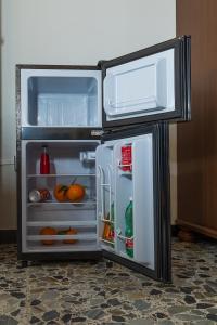 an open refrigerator with its door open in a kitchen at Pala Cerbu in Mògoro