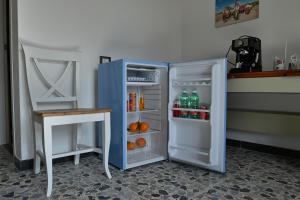 a blue refrigerator with its door open next to a table at Pala Cerbu in Mògoro