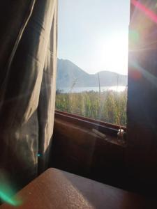 a window with a view of a field of crops at Minkay-Lodge in Otavalo +4 photos