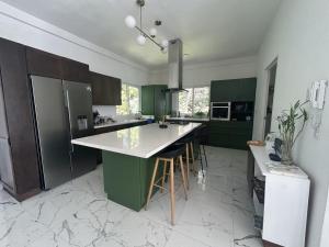 a kitchen with green cabinets and a white counter top at Quinta Pompella in San Salvador