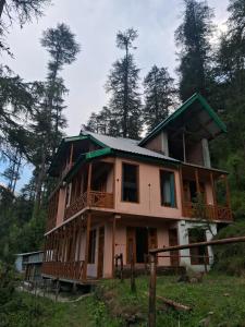 a large house on a hill with trees at Bhindeshi Tara Stays Jibhi Mihar in Jibhi