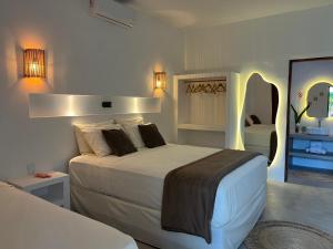 a bedroom with a large bed and a mirror at Casa Ninho in Atins