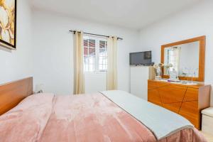 a bedroom with a bed and a dresser and a mirror at The Refuge Mosteiros house in Mosteiros