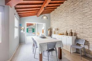 a kitchen with a table and chairs in a room at The Refuge Mosteiros house in Mosteiros