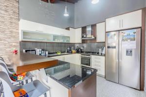 a large kitchen with a stainless steel refrigerator at The Refuge Mosteiros house in Mosteiros +3 photos