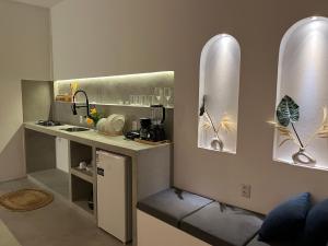 a kitchen with a counter with a sink and mirrors at Casa Ninho in Atins