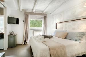 a white bedroom with a bed with towels on it at Iblainsuite in Ragusa