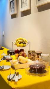 a table with a yellow table cloth with food on it at Pousada Tropeira in Lapa