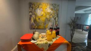 a table with drinks and a painting on the wall at Pousada Tropeira in Lapa +16 photos