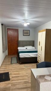 a small bedroom with a bed and a door at Pousada Tropeira in Lapa