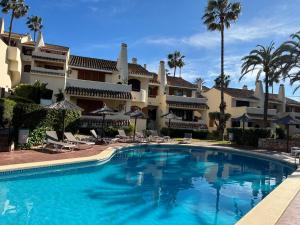 a swimming pool in front of a large building at La Manga Club, Las Palmeras 12 in La Manga del Mar Menor
