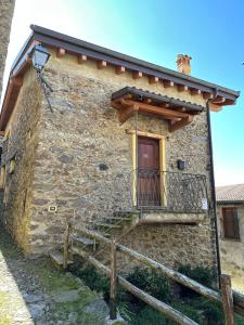 a stone building with a staircase and a balcony at Chalet La Terrazza Vista Lago in Bellano