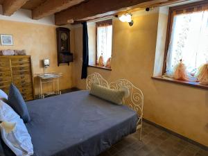 a bedroom with a blue bed and two windows at Chalet La Terrazza Vista Lago in Bellano