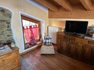 a living room with a flat screen tv and a window at Chalet La Terrazza Vista Lago in Bellano