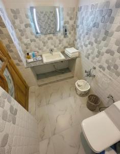a white bathroom with a sink and a toilet at Faizzy residency in Srinagar