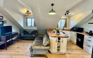 a kitchen with a couch and a table in a room at The Coach House in Torpoint
