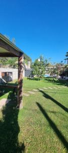 a grassy yard with a house and a pole at Maranatha in Rufino