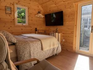 a bedroom with a bed and a flat screen tv at Avondale Lytham - Private Luxury Pod - Walk to Lytham Green in Lytham St Annes