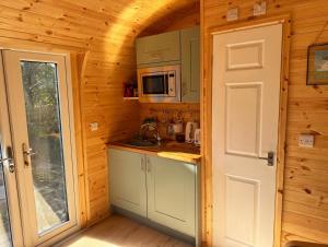 a kitchen in a wooden cabin with a microwave at Avondale Lytham - Private Luxury Pod - Walk to Lytham Green in Lytham St Annes