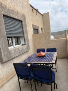 a table and chairs on the balcony of a house at Tiwaline Tarsime App E in Sidi Ifni