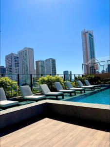 a row of lounge chairs sitting on top of a building at Apartamento 1 quarto Goiânia in Goiânia