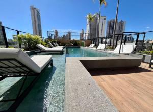a swimming pool with lounge chairs on top of a building at Apartamento 1 quarto Goiânia in Goiânia