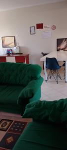 a living room with a green couch and a table at ΚΑΡΔΙΤΣΑ οικογενειακο in Karditsa