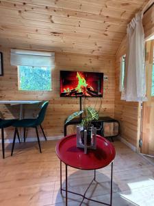 a living room with a fireplace in a log cabin at Pipowagen aan het Wandelpad in Lanaken