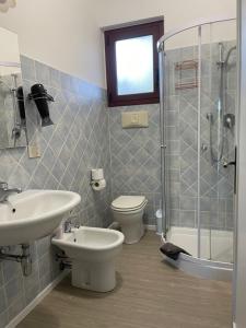 a bathroom with a sink and a toilet and a shower at Sea Rocks House in Olbia +11 photos
