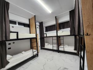 a room with three bunk beds in a room at The HANGOUT Hostel in Sarandë