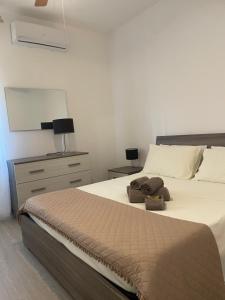 a bedroom with a large bed and a dresser with a lamp at Sea Rocks House in Olbia