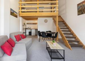 a living room with a couch and a staircase at KING rooms in Bečej