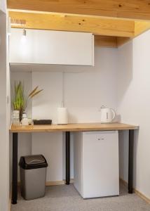 a kitchen with a table and a refrigerator at KING rooms in Bečej +8 photos